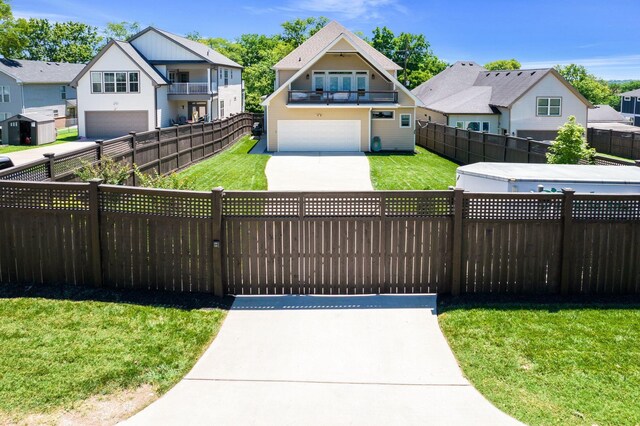 view of front of home with a garage, a front lawn, and a balcony