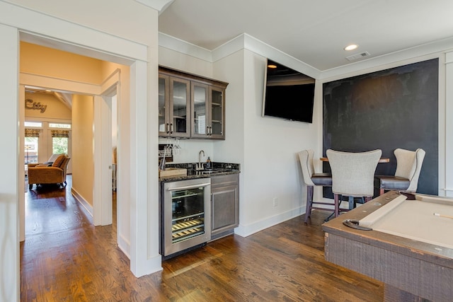 bar with dark hardwood / wood-style floors, sink, beverage cooler, pool table, and dark brown cabinets