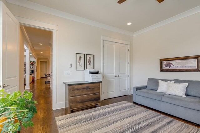 living room featuring dark hardwood / wood-style flooring, ornamental molding, and ceiling fan