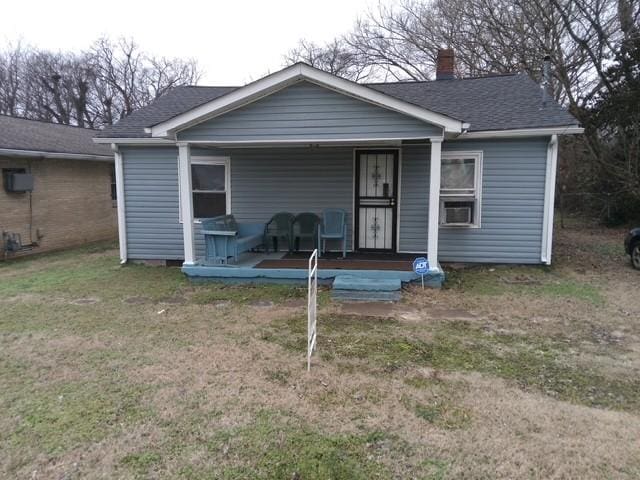 back of property featuring a porch and a lawn