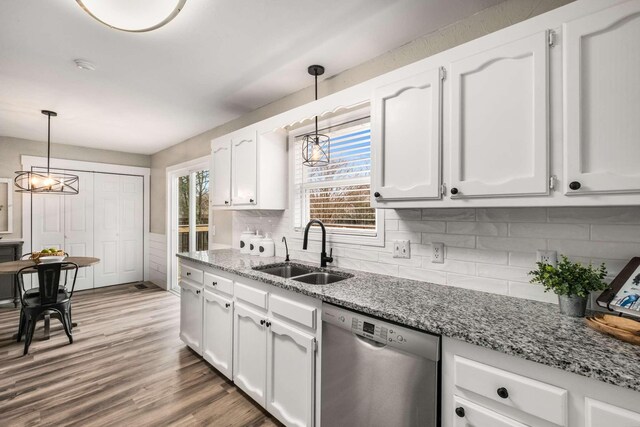 kitchen with white cabinetry, pendant lighting, sink, and stainless steel dishwasher