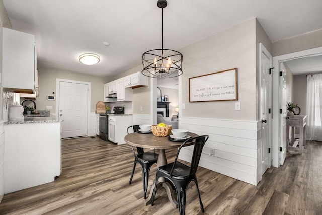 dining space with a notable chandelier, sink, and dark hardwood / wood-style floors