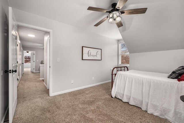 bedroom with lofted ceiling, light colored carpet, and ceiling fan