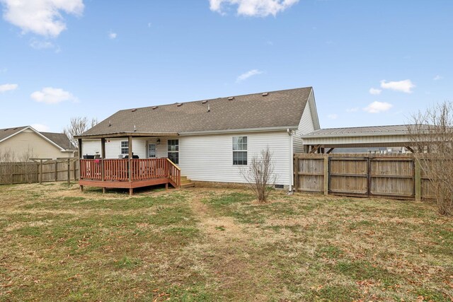 back of property featuring a wooden deck and a lawn