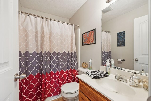 bathroom featuring vanity, a textured ceiling, and toilet