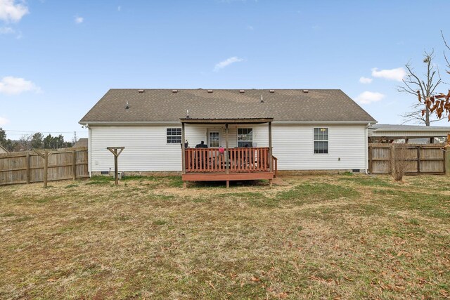 rear view of property featuring a wooden deck and a yard