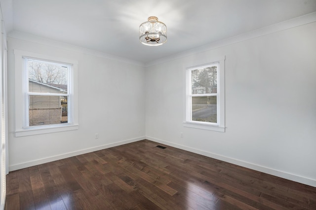 unfurnished room featuring dark hardwood / wood-style flooring, ornamental molding, and a chandelier