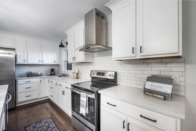 kitchen featuring white cabinetry, dark wood-type flooring, stainless steel appliances, and wall chimney exhaust hood