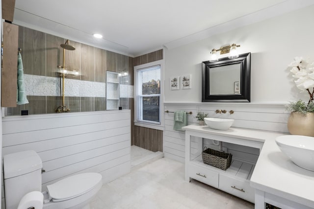 bathroom with tile walls, vanity, ornamental molding, a shower, and toilet