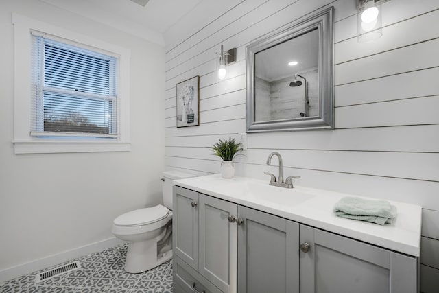 bathroom with vanity, tile patterned floors, toilet, and wood walls