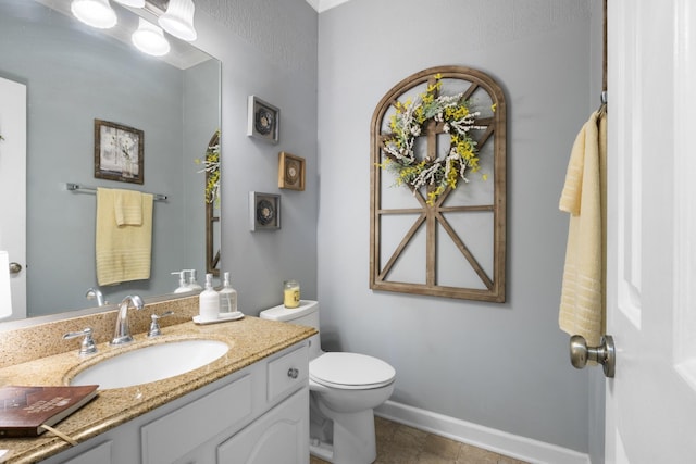 bathroom with tile patterned flooring, vanity, and toilet