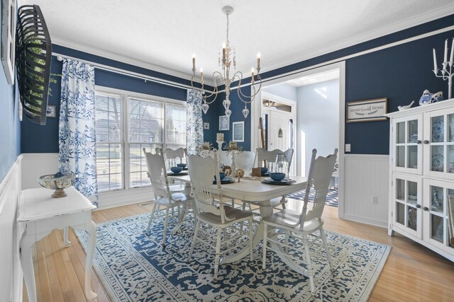 dining room with crown molding, wood-type flooring, and a chandelier