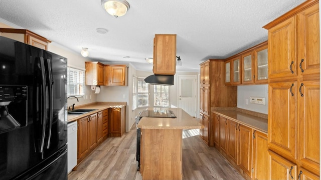 kitchen featuring sink, dishwasher, a center island, light hardwood / wood-style floors, and black refrigerator with ice dispenser