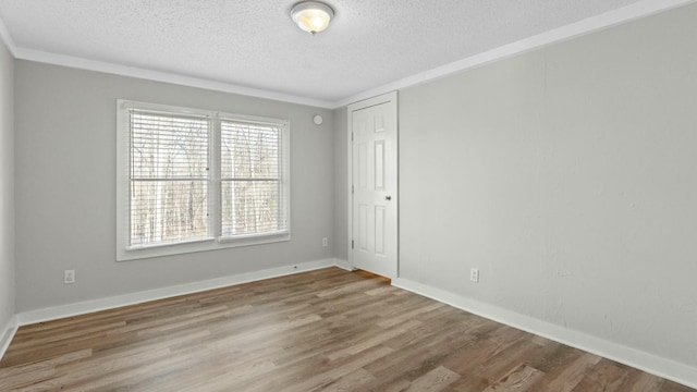 empty room with crown molding, hardwood / wood-style floors, and a textured ceiling