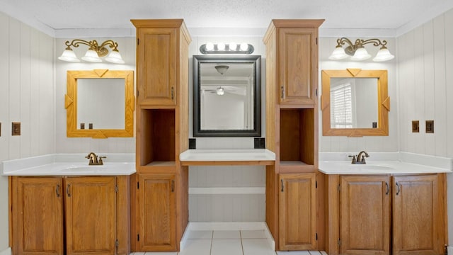 bathroom with ornamental molding, tile patterned floors, vanity, and a textured ceiling