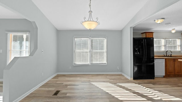 unfurnished dining area with sink and light hardwood / wood-style flooring