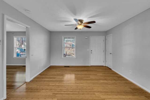 unfurnished room with ceiling fan, plenty of natural light, light hardwood / wood-style floors, and a textured ceiling