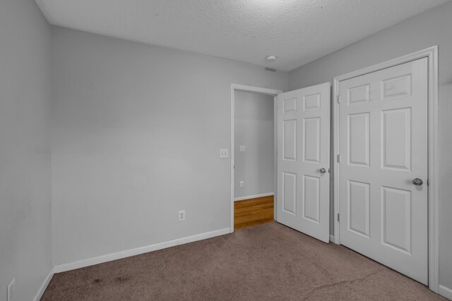 unfurnished bedroom with carpet floors and a textured ceiling