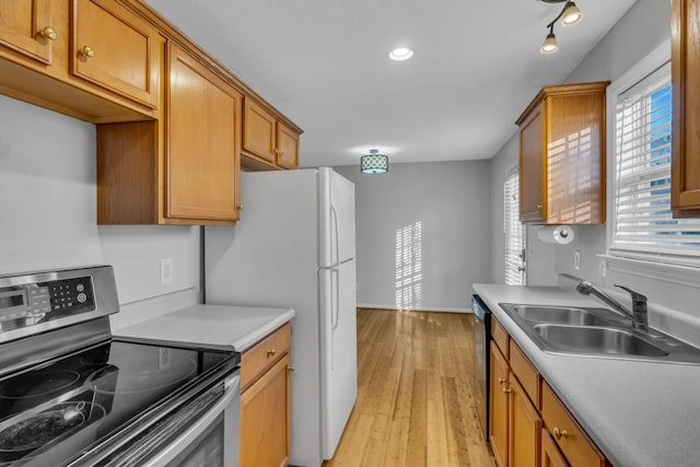 kitchen with black dishwasher, sink, white refrigerator, light wood-type flooring, and electric stove