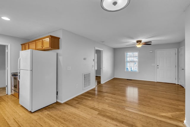 kitchen featuring white refrigerator, ceiling fan, stainless steel electric stove, and light hardwood / wood-style floors