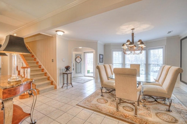 dining space with a notable chandelier, crown molding, and light tile patterned flooring