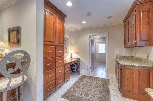 kitchen featuring crown molding, light stone countertops, and light tile patterned flooring