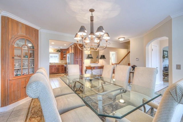 tiled dining space featuring ornamental molding and a chandelier