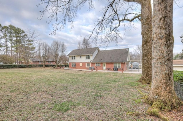 rear view of property featuring a patio and a lawn