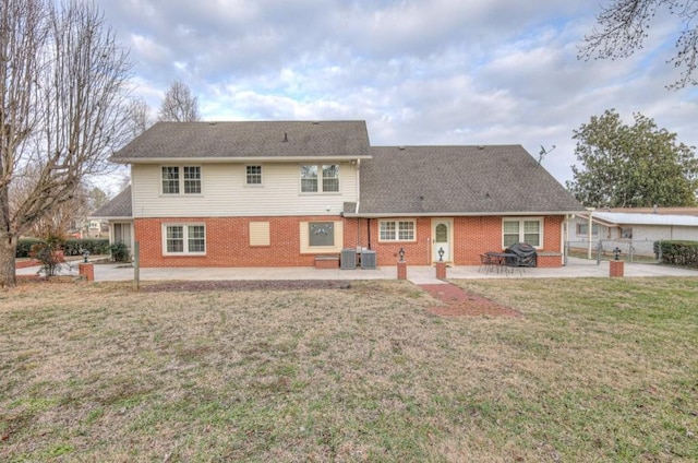 rear view of house with a yard, cooling unit, and a patio area