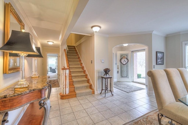 tiled foyer featuring ornamental molding and a healthy amount of sunlight