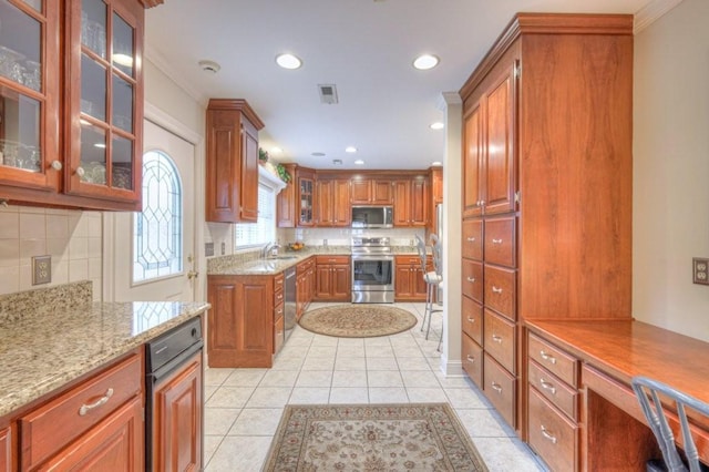 kitchen with light tile patterned flooring, sink, tasteful backsplash, stainless steel appliances, and light stone countertops