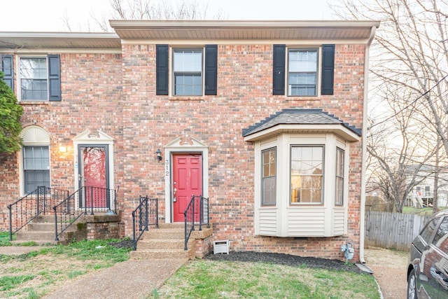 view of front of property featuring brick siding and fence