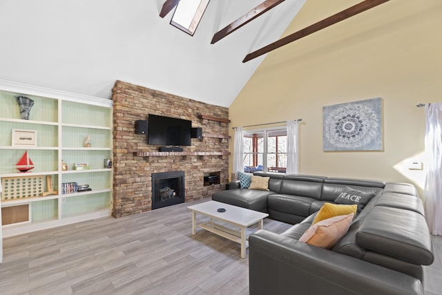 living room with light hardwood / wood-style flooring, vaulted ceiling with beams, and a fireplace