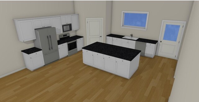 kitchen featuring a kitchen island, stainless steel stove, refrigerator, white cabinetry, and sink