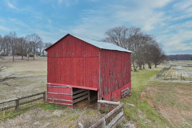 view of outdoor structure with a rural view and a lawn