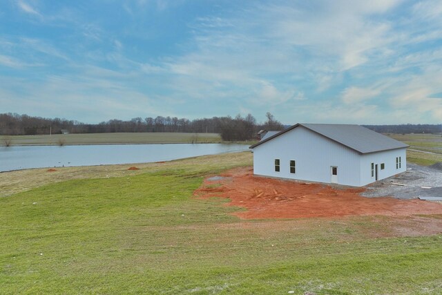 view of home's exterior with a water view and a lawn