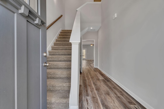 staircase with wood finished floors and baseboards