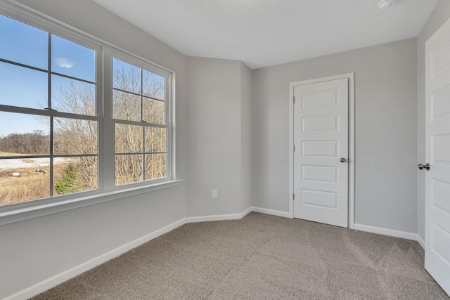 empty room featuring carpet floors and baseboards