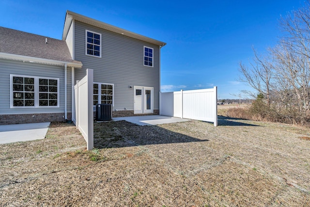 back of property with central AC, a patio, and fence