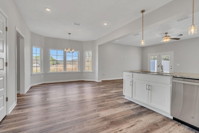 kitchen featuring light stone counters, a sink, visible vents, white cabinets, and stainless steel dishwasher