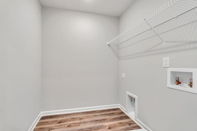 laundry area with laundry area, washer hookup, wood finished floors, and electric dryer hookup