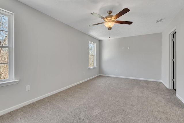 unfurnished bedroom featuring light carpet, visible vents, baseboards, and ceiling fan