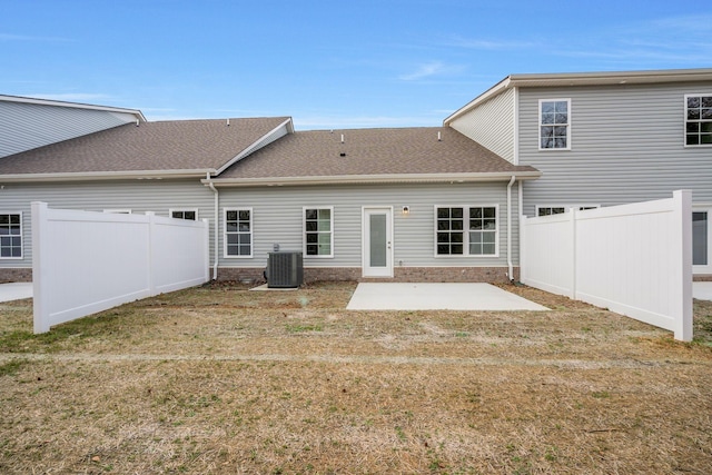 back of property featuring a lawn, a patio area, fence private yard, and central air condition unit