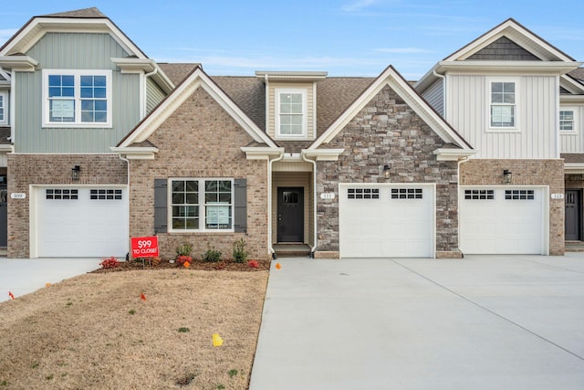 craftsman inspired home with a garage, concrete driveway, and roof with shingles