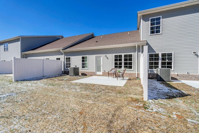 rear view of property with roof with shingles, a patio area, fence, and central AC unit