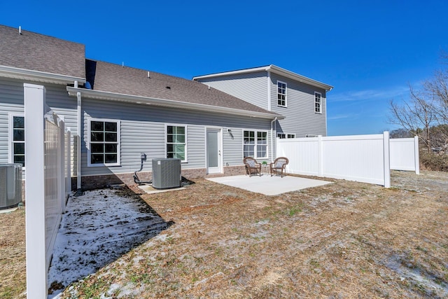 rear view of property featuring a patio area, a shingled roof, fence, and cooling unit