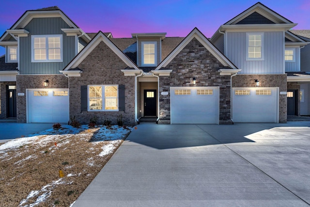 craftsman house featuring concrete driveway, brick siding, and board and batten siding