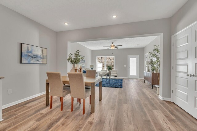 dining room featuring recessed lighting, a textured ceiling, baseboards, and wood finished floors