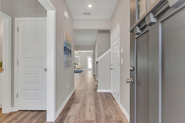 foyer entrance featuring wood finished floors, visible vents, and baseboards