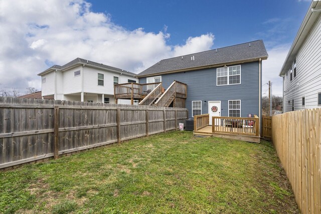 rear view of property featuring a deck and a lawn